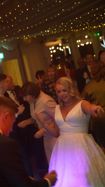 A bride smiling on a busy dance floor