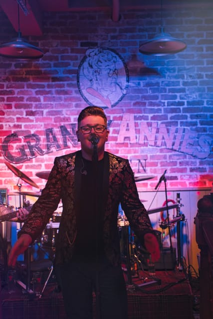 Adam on stage at Granny Annie’s, arms out